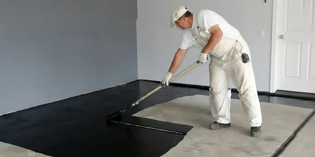 basement waterproofing professional applying waterproof coating to protect a basement floor in Pasadena, CA