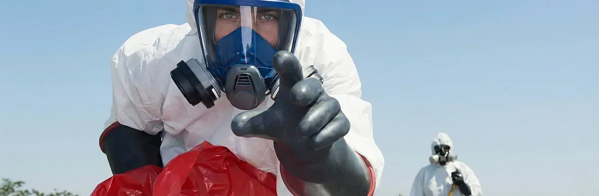 sewage clean up technician wearing protective gear handling biohazard materials in Pasadena, CA